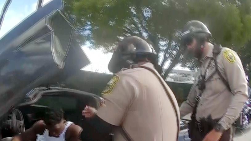 Police body camera video shows that an officer dragging Miami Dolphins wide receiver Tyreek Hill out of his sports car by his arm and head and then forcing him face first onto the ground after Hill put up the window of his sports car. (Miami-Dade Police Department)