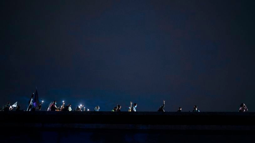 FILE - People march along Las Americas Highway to protest the LUMA Energy company in San Juan, Puerto Rico, Oct. 15, 2021. (AP Photo/Carlos Giusti, File)