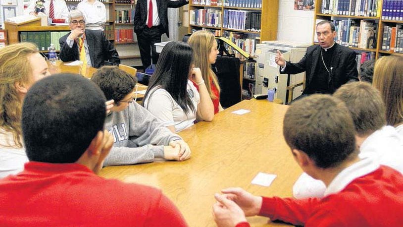 In this file photo, Cincinnati Archbishop Dennis M. Schnurr talks with students at the Carroll High School library. FILE