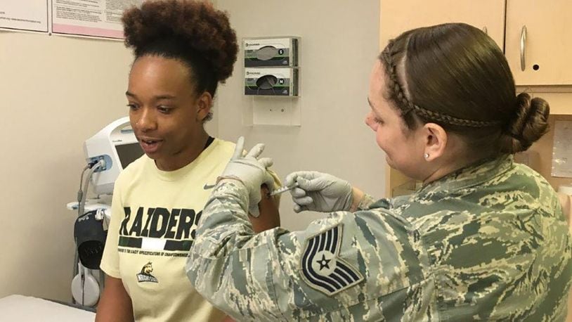 Tech. Sgt. Amanda Buckholdt (right), Wright-Patterson Medical Center Allergy and Immunizations section chief, and Kayle Willis, Allergy and Immunizations administrative technician, demonstrate how the Immunization Clinic administers vaccines to patients on a daily basis. (U.S. Air Force photo/Kimberly Gaither)