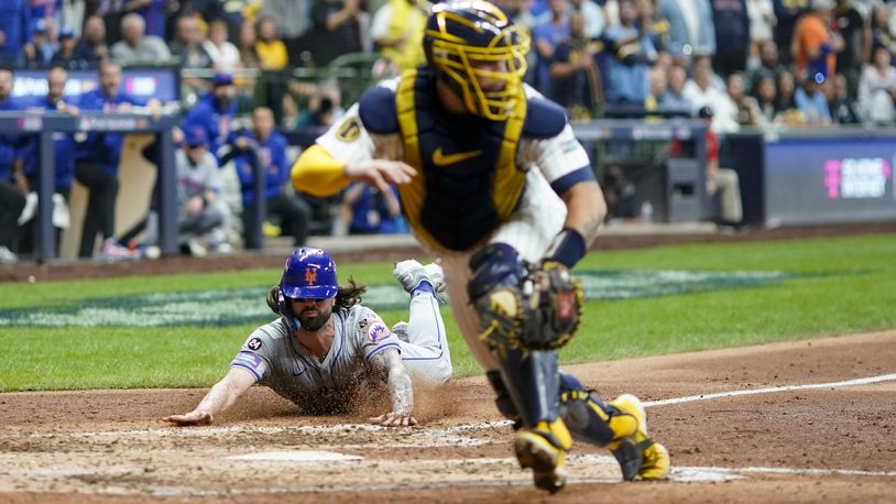 New York Mets' Jesse Winker slides safely home on a hit by Starling Marte Milwaukee Brewers catcher Gary Sánchez during the ninth inning of Game 3 of a National League wild card baseball game against the Milwaukee Brewers Thursday, Oct. 3, 2024, in Milwaukee. (AP Photo/Morry Gash)