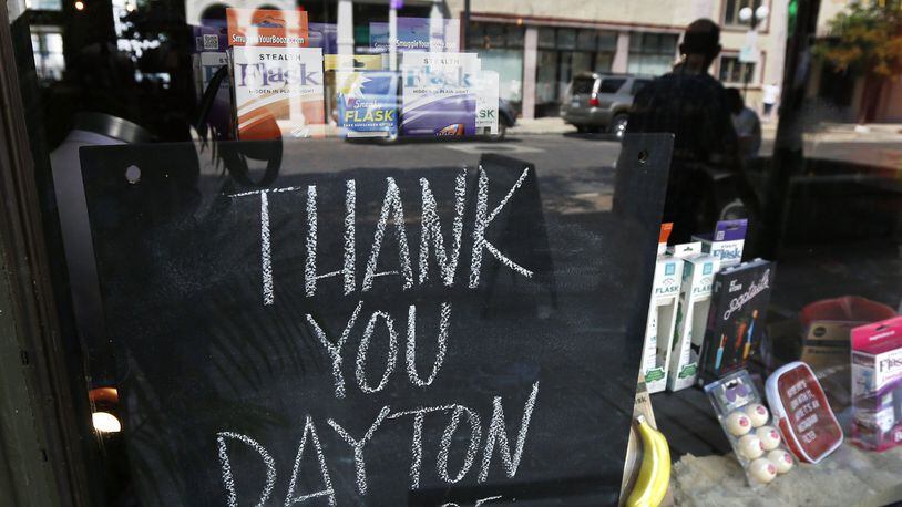 Signs supporting the Dayton Police Department can be found throughout the Oregon District, including this chalkboard sign at Heart Mercantile. TY GREENLEES / STAFF