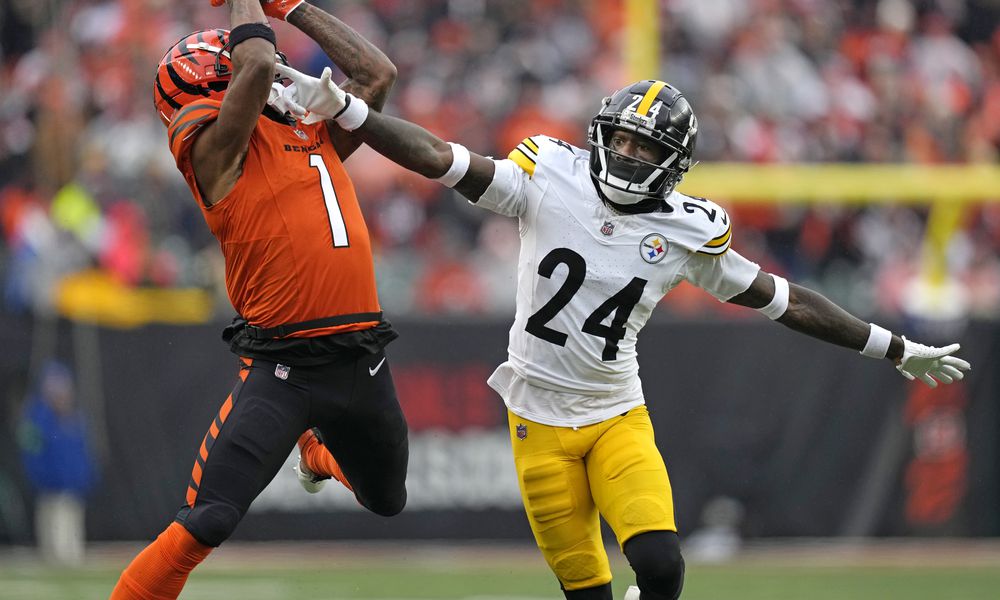 Cincinnati Bengals wide receiver Ja'Marr Chase (1) catches a pass from quarterback Jake Browning for a first down with Pittsburgh Steelers cornerback Joey Porter Jr. (24) defending during the second half of an NFL football game in Cincinnati, Sunday, Nov. 26, 2023. (AP Photo/Carolyn Kaster)