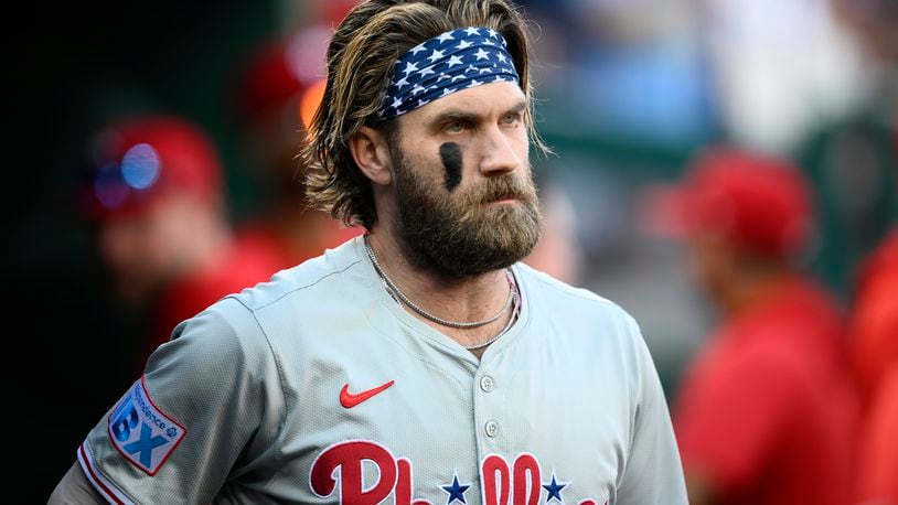 Philadelphia Phillies' Bryce Harper looks on from the dugout before a baseball game against the Washington Nationals, Saturday, Sept. 28, 2024, in Washington. (AP Photo/Nick Wass)