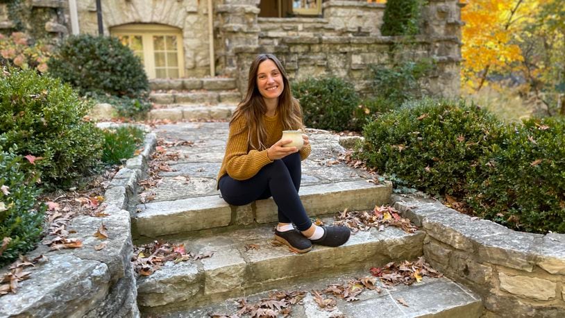Sarena Kelley enjoys a cup of tea on the steps of her Oakwood home. Photo by Robin McMacken