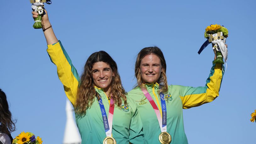 FILE- First placed Brazil's Kahena Kunze, right, and Martine Grael celebrate their gold medal at the end of the women's 49er FX at the 2020 Summer Olympics, Tuesday, Aug. 3, 2021, in Fujisawa, Japan. (AP Photo/Bernat Armangue, File)