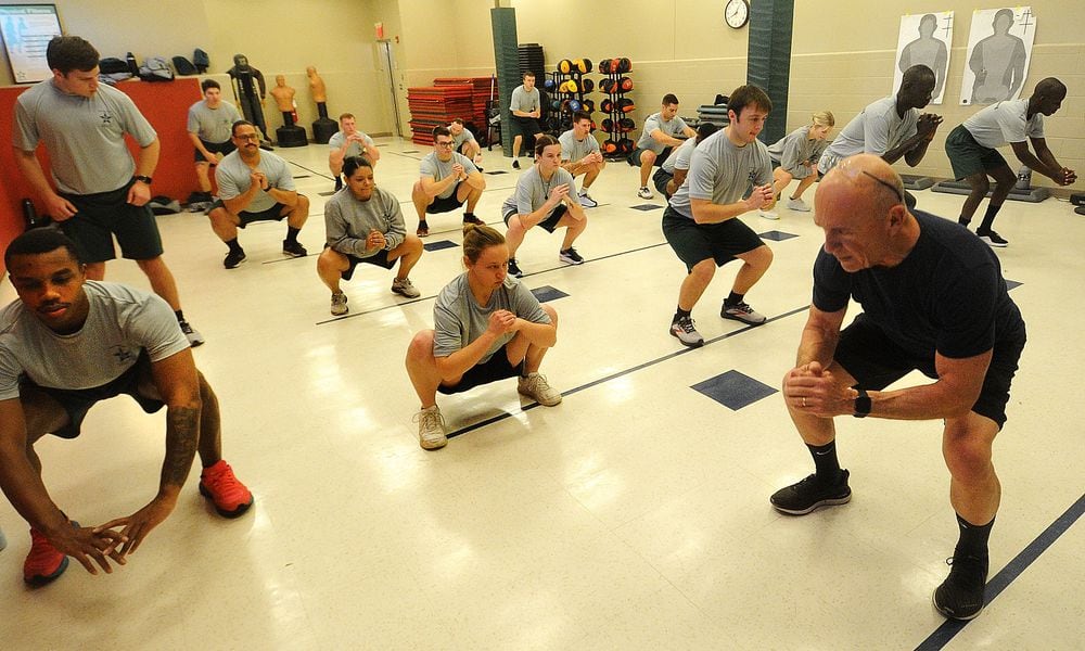 Police cadets at Sinclair Community College perform air squats as part of morning physical training, Thursday, Jan. 11, 2024. MARSHALL GORBY\STAFF