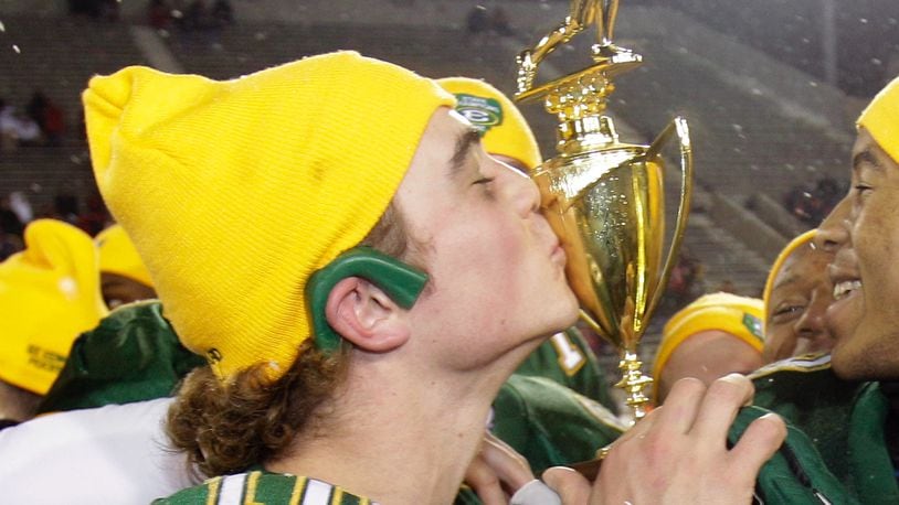 St. Edward quarterback Kevin Burke, left, kisses the trophy after St. Edward beat Wayne 35-28 in the Division I high school football championship football game Saturday, Dec. 4, 2010, in Canton, Ohio. (AP Photo/Tony Dejak)