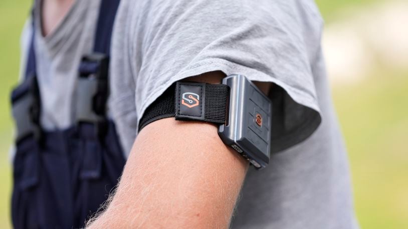 A SafeSlate armband is worn by Wyatt Fischer, a furnace mason employee at Cardinal Glass Factory, Thursday, Aug. 22, 2024, in Menomonie, Wisconsin. As global temperatures rise and summer months bring record high temperatures, employers are exploring wearable technologies to keep workers safe. (AP Photo/Abbie Parr)