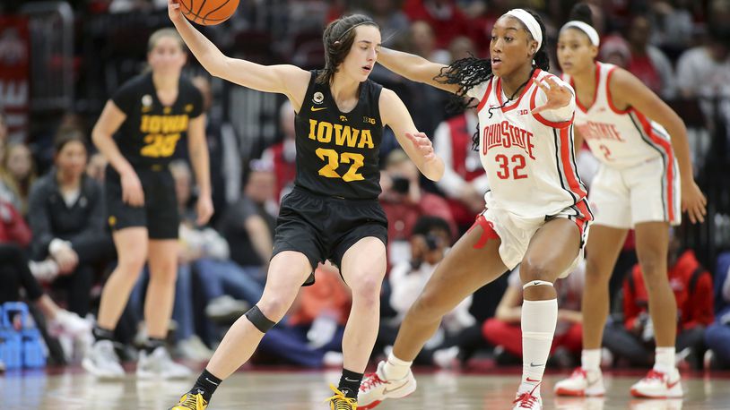 Iowa guard Caitlin Clark, left, controls a pass as Ohio State forward Cotie McMahon (32) defends during the second half of an NCAA college basketball game at Value City Arena in Columbus, Ohio, Monday, Jan. 23, 2023. (AP Photo/Joe Maiorana)