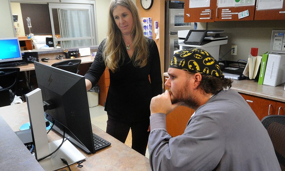 Carrie Carusone, Joint and Spine Program director at Greater Dayton Surgery Center, talks with Dr. Ross Brubaker at the Greater Dayton Surgery Center. MARSHALL GORBY\STAFF