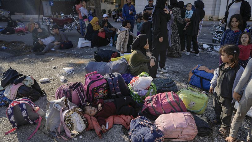 Families gather in Martyrs' square after fleeing the Israeli airstrikes in Beirut's southern suburbs, Saturday, Sept. 28, 2024. (AP Photo/Bilal Hussein)