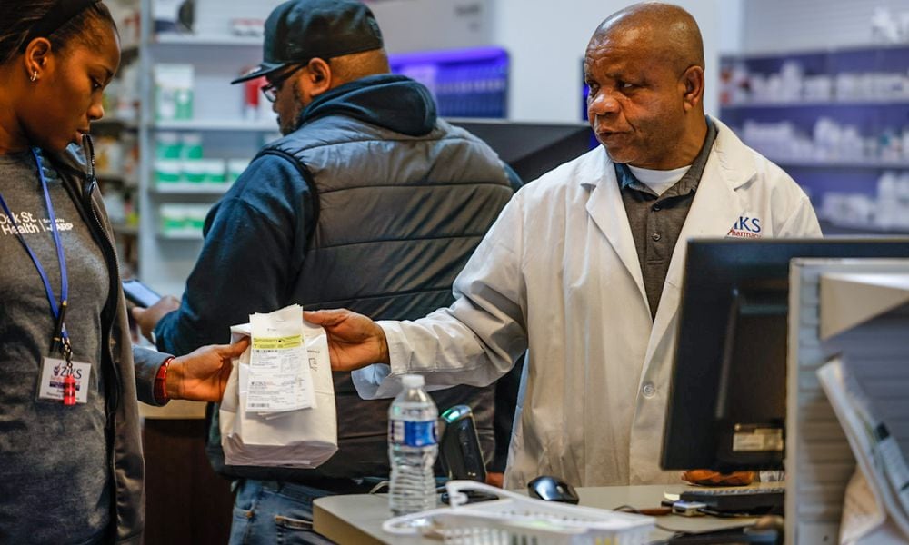 Ziks Family Pharmacist, Nnodum Iheme, right, works with pharmacy technician, Joy Duaka at the pharmacy on East Third St. Wednesday November 30, 2022. Starting in January 2025, Medicare Part D enrollees will have their out-of-pocket spending for prescription medication capped at $2,000 a year. JIM NOELKER/STAFF FILE