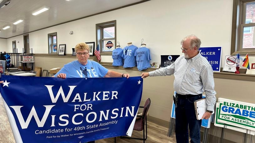 Grant County Democratic Party Chair Joyce Bos, left, and Democratic legislative candidate Scott Abbot Walker inspect a campaign banner Friday, Sept. 6, 2024, in the county party headquarters in Platteville, Wis. (AP Photo/Todd Richmond)