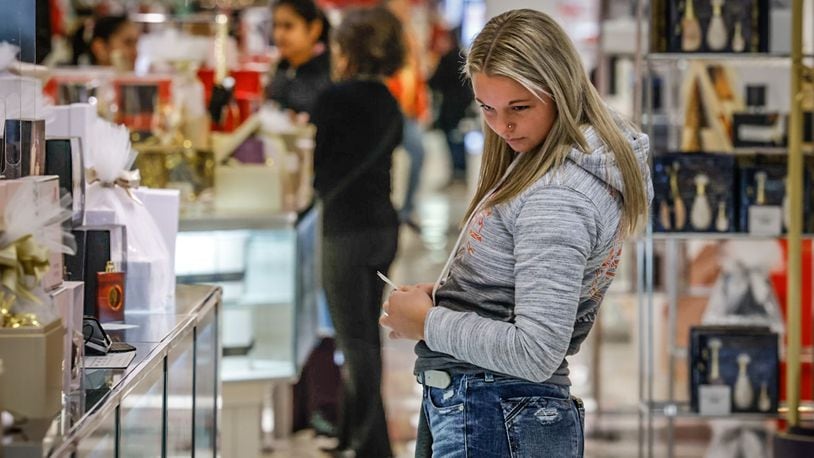 A shopper in Macy's at the Dayton Mall peruses the fragrance section of the store Wednesday December 21, 2022. The Dayton Mall was busy with Christmas just days away and online shipping deadlines passed. JIM NOELKER/STAFF