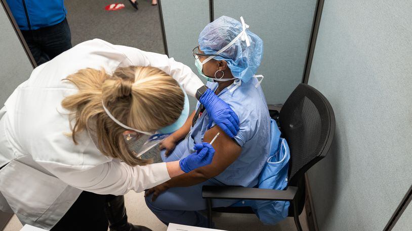 Pictured is a healthcare worker at UC Health in Cincinnati receiving on Monday, Dec. 14, 2020, the new novel coronavirus vaccine developed by Pfizer. Ohio received its first deliveries of the COVID-19 vaccine on Monday and UC Health was one of the first in Southwest Ohio to receive it. PROVIDED/UC HEALTH