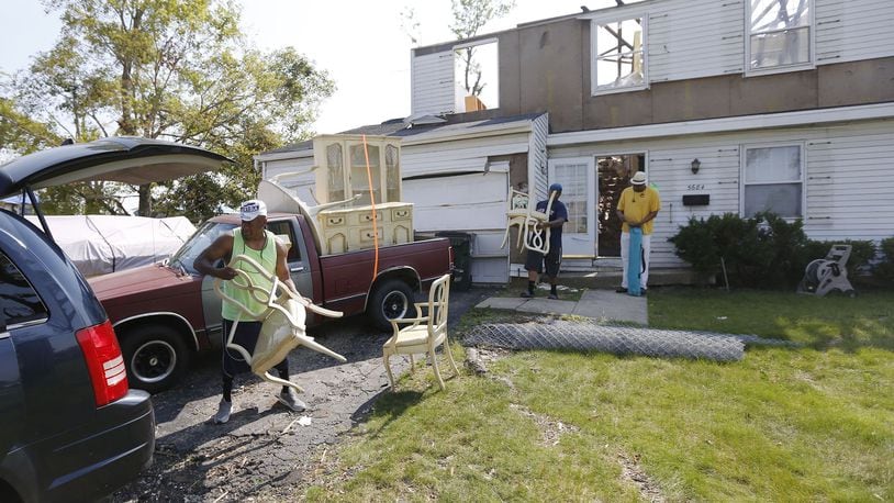 Friends move furniture of a tornado victim in Trotwood. Repairs are underway or waiting for insurance settlements in communities throughout the Dayton area one month after the Memorial Day tornadoes tore through many neighborhoods. TY GREENLEES / STAFF