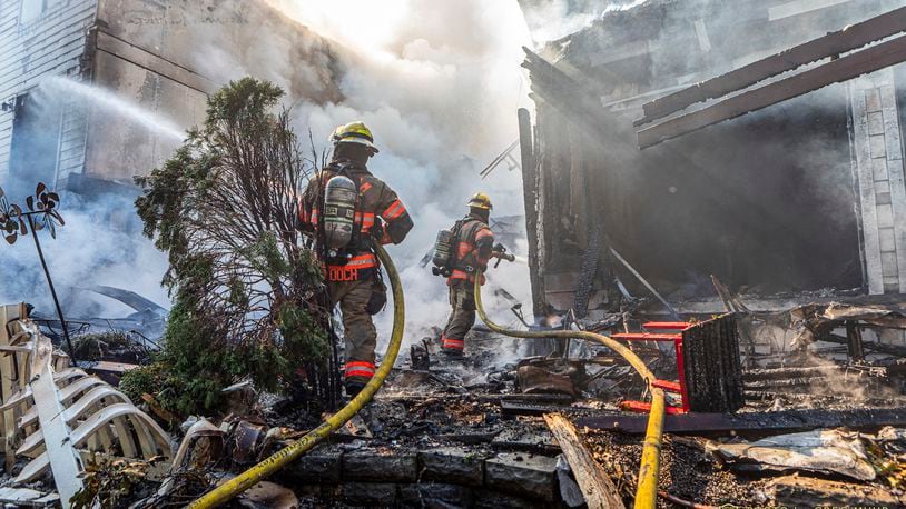 In this photo provided by Portland Fire & Rescue, firefighters use handlines to extinguish the fire adjacent to the primary structure involved after a small plane crashed Saturday, Aug. 31, 2024, in Fairview, Ore. (Greg Muhr/Portland Fire & Rescue via AP)