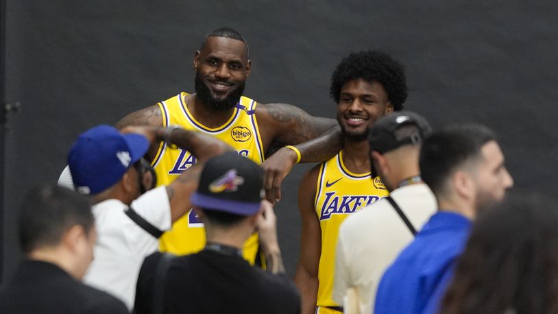 Los Angeles Lakers' LeBron James, left, and his son, Bronny James, pose for photos during the NBA basketball team's media day in El Segundo, Calif., Monday, Sept. 30, 2024. (AP Photo/Jae C. Hong)