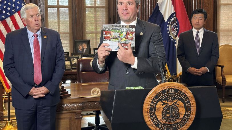 Missouri Attorney General Andrew Bailey holds up photos of candy-like products containing unregulated psychoactive cannabis ingredients that he says are being marketed to children during a press conference Tuesday, Sept. 10, 2024, at the governor's office at the state Capitol in Jefferson City, Mo. (AP Photo/David A. Lieb)