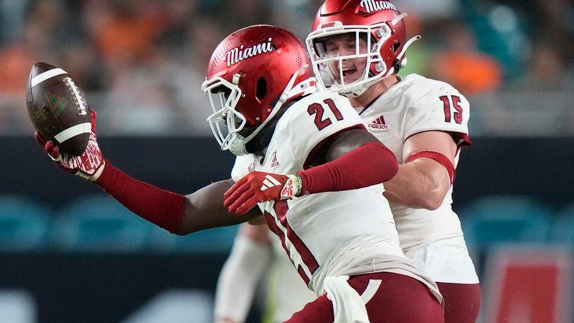 Miami (Ohio) defensive back Michael Dowell (21) celebrates with linebacker Matt Salopek (15) after Dowell intercepted the ball during the first half of an NCAA college football game against Miami, Friday, Sept. 1, 2023, in Miami Gardens, Fla. (AP Photo/Wilfredo Lee)