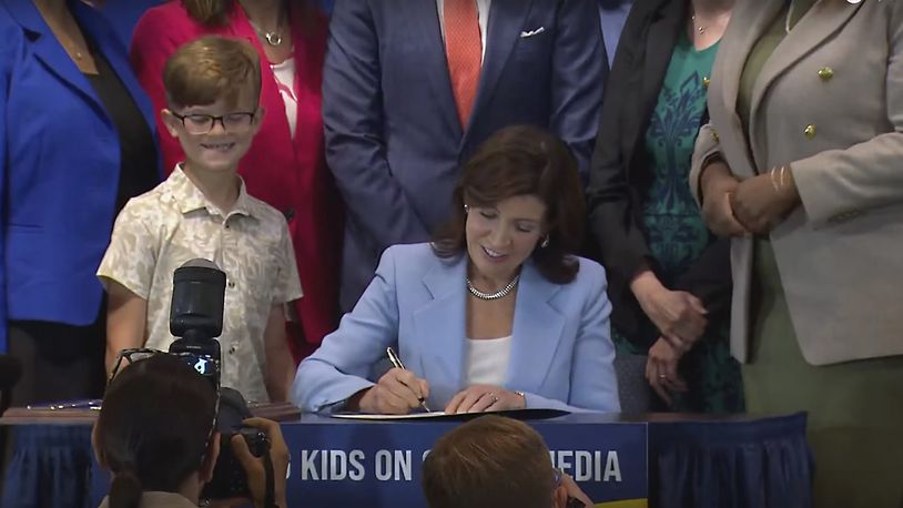 In this still image taken from video of the Office of the New York Governor, Gov. Kathy Hochul signs a bill, in New York, Thursday, June 20, 2024. Hochul signed a bill that would allow parents to block their children from getting social media posts suggested by a platform's algorithm, a move to limit feeds critics argue are addictive. (Office of the New York Governor via AP)
