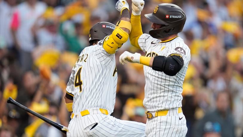 San Diego Padres' Kyle Higashioka, right, celebrate his solo home run with Luis Arraez during the second inning in Game 2 of an NL Wild Card Series baseball game against the Atlanta Braves, Wednesday, Oct. 2, 2024, in San Diego. (AP Photo/Gregory Bull)