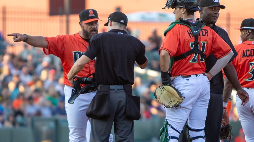 Dayton pitching coach Brian Garman argues with umpire Justin Hopkins after Hopkins ejected him in the second inning Friday night at Day Air Ballpark. Jeff Gilbert/CONTRIBUTED