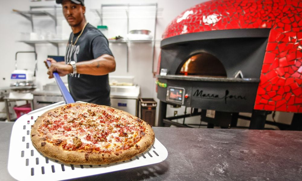 ILLY'S Fire Pizza owner, Robert Gunn, pulls out a fresh pizza from the oven at W. Social Tap & Table. JIM NOELKER/STAFF