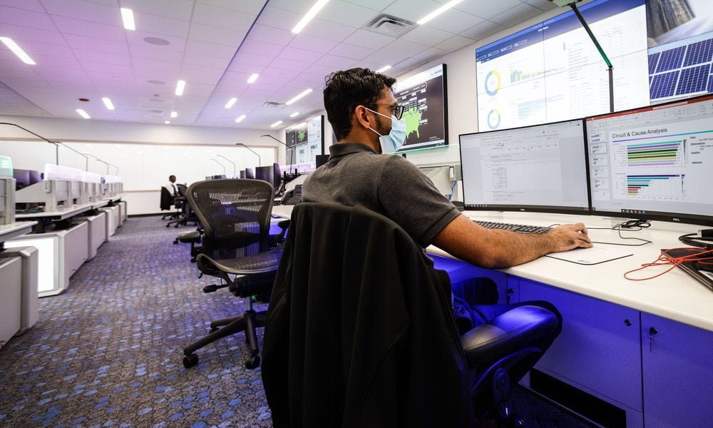 AES data scientist, Kashyap Mehta works in his new office at the newly remodeled AES smart operations center on Woodman Dr. AES spent $20 million to renovate the old Dayton Power & Light building and move AES into the future. JIM NOELKER/STAFF