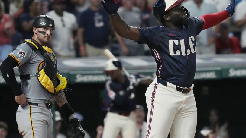 Cleveland Guardians' Jhonkensy Noel, right, celebrates in front of Pittsburgh Pirates catcher Yasmani Grandal, left, after hitting a home run in the fifth inning of a baseball game, Friday, Aug. 30, 2024, in Cleveland. (AP Photo/Sue Ogrocki)