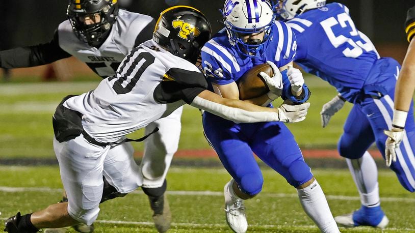 Wyoming's Joel Hancock is tackled by Shawnee's Hayden Coppess during Friday's playoff game. BILL LACKEY/STAFF