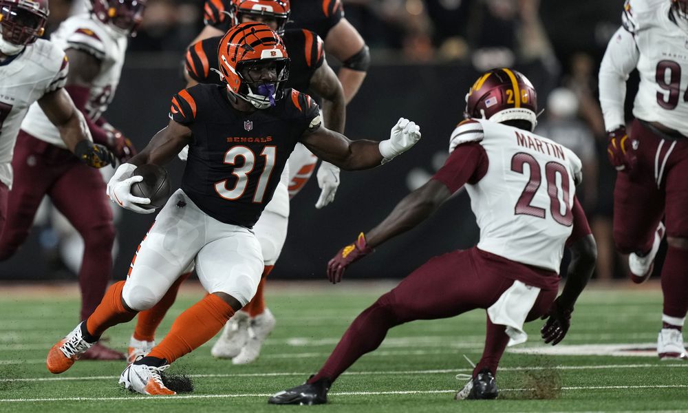 Cincinnati Bengals running back Zack Moss (31) runs from Washington Commanders safety Quan Martin (20) during the first half of an NFL football game, Monday, Sept. 23, 2024, in Cincinnati. (AP Photo/Carolyn Kaster)