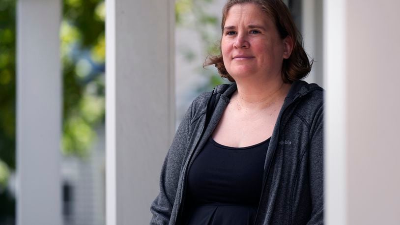 Rebecca Wood stands for a portrait outside her home, Friday, Aug. 30, 2024, in Maynard, Mass. Wood noticed a "program fee" required each time she loaded money onto her daughter's school lunch account. (AP Photo/Charles Krupa)