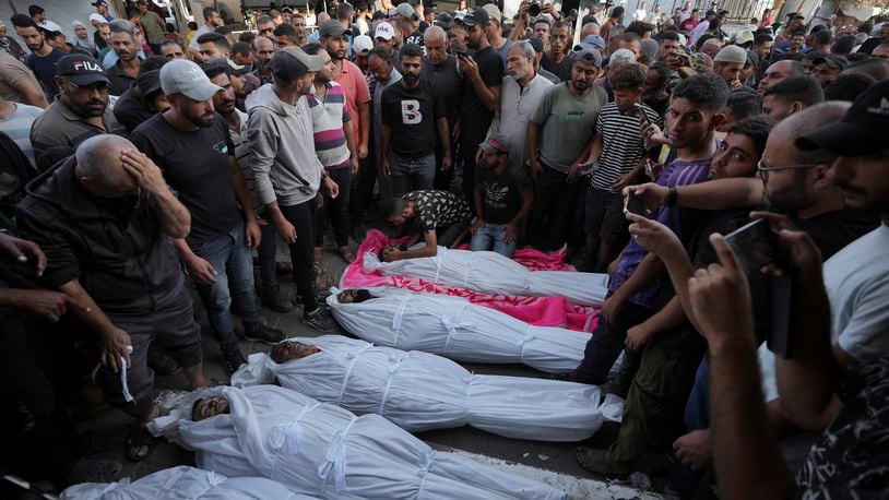 Mourners gather around the bodies of Palestinian men who were killed in an Israeli airstrike in Deir al-Balah, Gaza, Sunday, Oct. 6, 2024. (AP Photo/Abdel Kareem Hana)