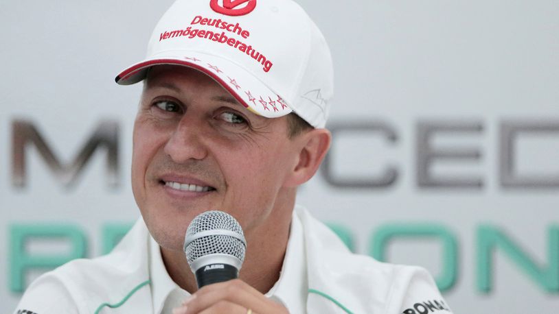 FILE - Michael Schumacher announces his retirement from Formula One during a press conference at the Suzuka Circuit venue for the Japanese Formula One Grand Prix in Suzuka, Japan, Oct. 4, 2012. German prosecutors say two men who allegedly tried blackmailing the family of former Formula 1 champion Michael Schumacher were detained earlier this month. Prosecutors in the western German city of Wuppertal said Monday the suspects told employees of the family that they were in possession of files that the family would not want to be published. (AP Photo/Itsuo Inouye, file)