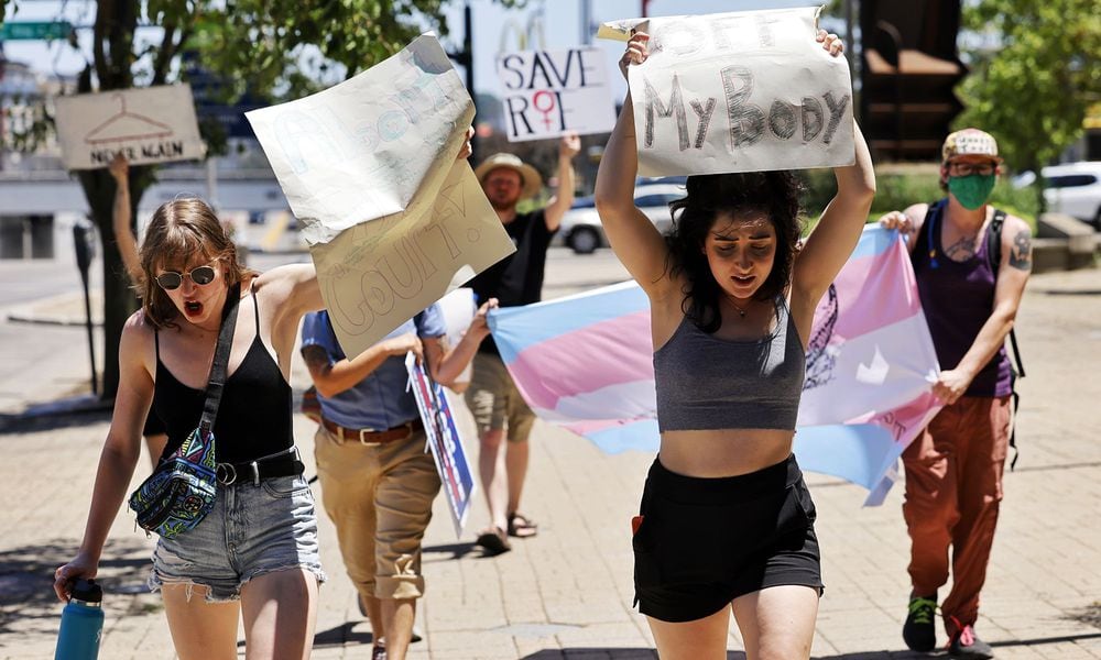 Lauren Whitehead, left, and Brooklyn Hubbard, right, lead a march along High Street after over 100 people gathered for a rally in support of women's rights and protest the overturning of Roe V. Wade Sunday afternoon, July 3, 2022 near the historic Butler County court house on High Street in Hamilton. Multiple speakers, several running for political office around the state, addressed the crowd. Chants such as 