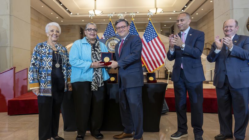 House Speaker Mike Johnson, R-La., center, presents a Congressional Gold Medal posthumously to Joylette Hylick, left, and Katherine Moore, daughters of Katherine Johnson, the Black NASA mathematician featured in the movie "Hidden Figures," at the Capitol in Washington, Wednesday, Sept. 18, 2024. They are joined by House Minority Leader Hakeem Jeffries, D-N.Y., second from right, and Sen. Chris Coons, D-Del. (AP Photo/J. Scott Applewhite)