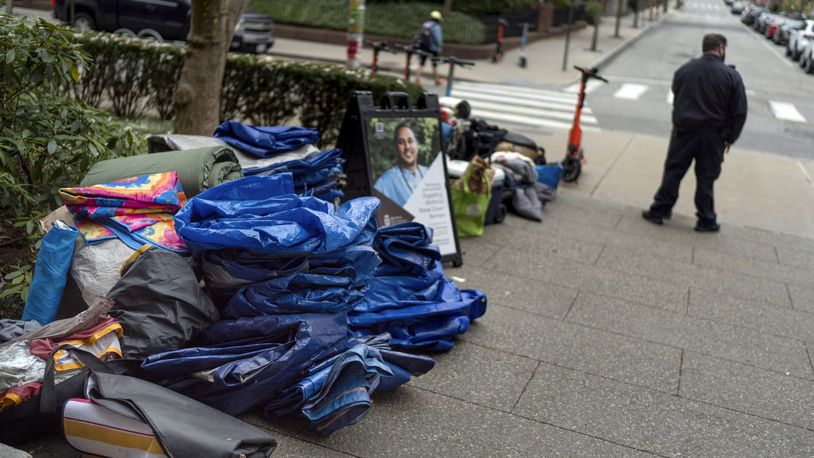 FILE - Tarps, sleeping bags and blankets sit piled on a sidewalk after an encampment protesting the Israel-Hamas war was taken down at Brown University as a campus security officer stands by, Tuesday, April 30, 2024, in Providence, R.I. (AP Photo/David Goldman, File)