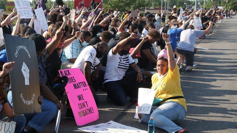 Protestors take a knee at a rally along Old Troy Pike in Huber Heights on Saturday, June 6, 2020. Bill Lackey/STAFF