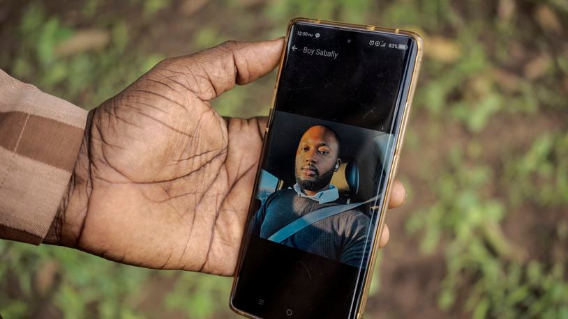 Moustapha Sabally displays a photo of his son who is a doctor in America on his mobile phone in the village of Kwinella, Gambia, on July 27, 2024. ( AP Photo/Annika Hammerschlag)