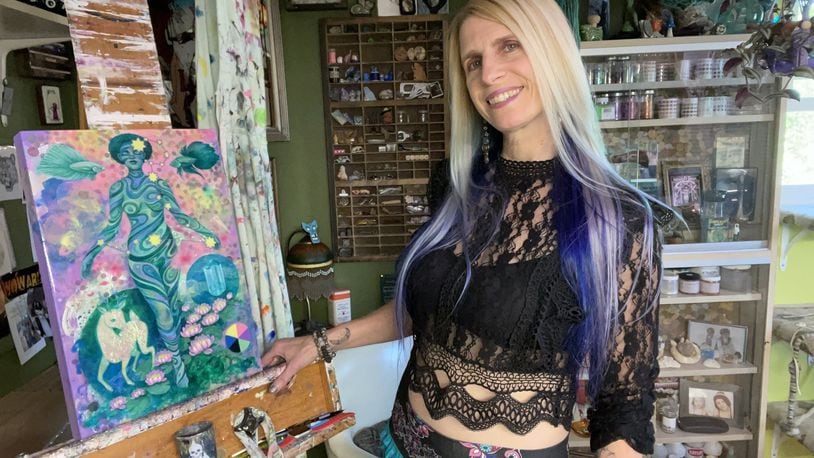 Amy Kollar Anderson stands in her home studio with a painting from her series “Rule Makers/Rule Breakers,” based on the structure of the zodiac constellations. CONTRIBUTED PHOTOS
