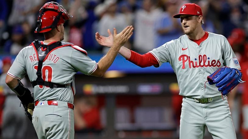 Philadelphia Phillies relief pitcher Jeff Hoffman, right, and catcher J.T. Realmuto (10) celebrate after defeating the New York Mets in a baseball game Friday, Sept. 20, 2024, in New York. (AP Photo/Adam Hunger)