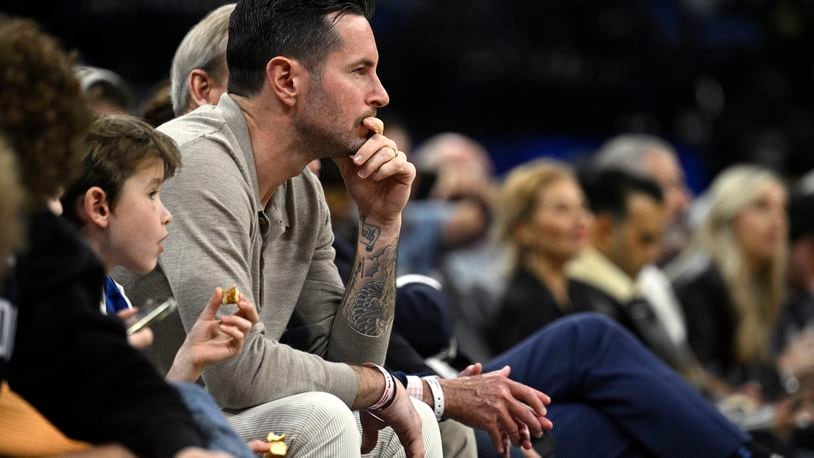 Former Orlando Magic guard JJ Redick, center, watches from a court side seat during the first half of an NBA basketball game, Feb. 14, 2024, in Orlando, Fla. Redick is being hired as the head coach of the Los Angeles Lakers, a person with knowledge of the decision tells The Associated Press. (AP Photo/Phelan M. Ebenhack, file)