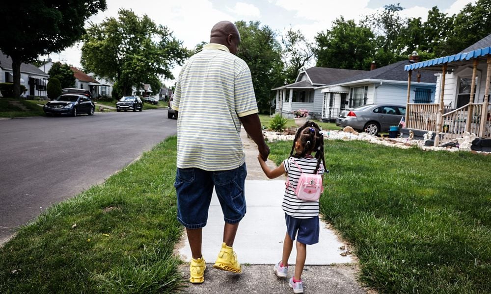 Quintinn Hardwick walks to the bus stop in his Dayton neighborhood with his daughter Arianna Alexis Hardwick on Friday, June 7, 2024. JIM NOELKER/STAFF