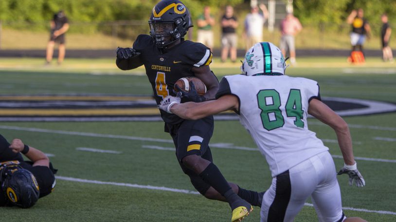 Centerville running back Emable Wakilongo runs past Dublin Coffman's Zach Beckman in the first half of Friday night's game against Dublin Coffman. CONTRIBUTED/Jeff Gilbert