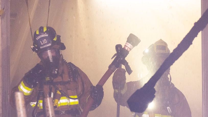 Firefighters with the 788th Civil Engineer Squadron Fire Department, work in the smoke, steam and water of a room on fire July 18 in building 18, on Area B, Wright-Patterson Air Force Base. Fifteen firefighters from the Wright-Patt Fire Department and 4 firefighters from the City of Riverside Fire Department responded to the alert. (Air Force photo by R.J. Oriez)