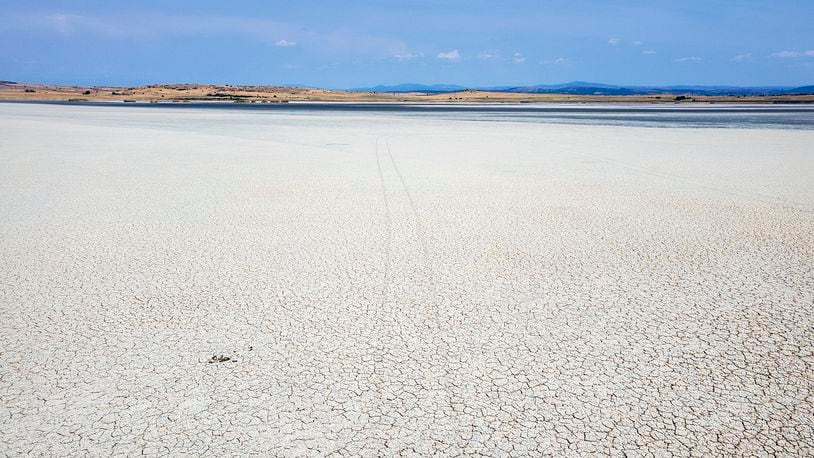 The dried out Lake Picrolimni is seen from above, in the village of Mikrokampos, northern Greece, Aug. 19, 2024. A severe drought in northern Greece, worsened by successive heatwaves and low rainfall, is causing water shortages that are threatening agriculture, drying up lakes, and stressing local communities dependent on tourism. (AP Photo/Giannis Papanikos)