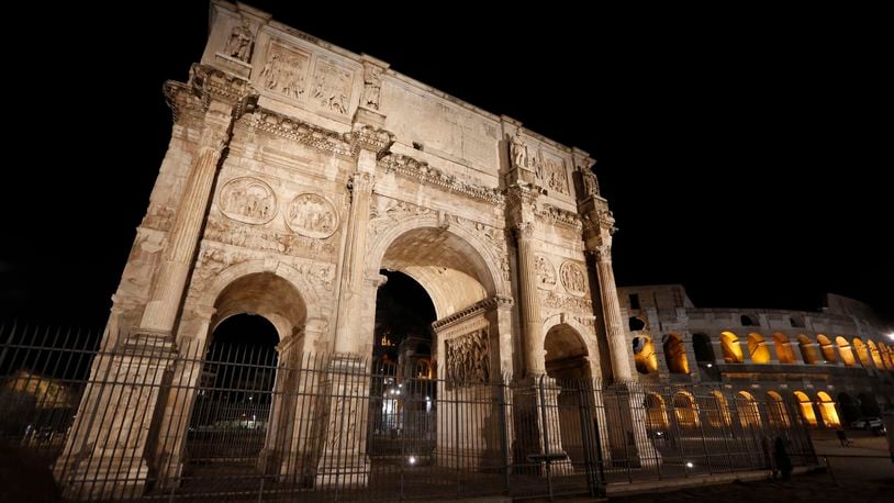 FILE -A view the Arch of Constantine, and the Colosseum, background right, on the occasion of the unveiling of new lightning, in Rome, July 17, 2020. (AP Photo/Riccardo De Luca, File)