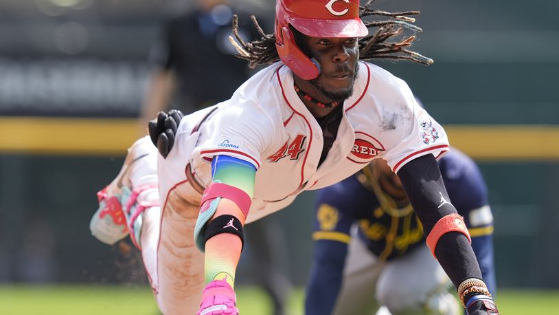 Cincinnati Reds' Elly De La Cruz dives into third as he advances on a throwing error by Milwaukee Brewers right fielder Sal Frelick, after hitting a double during the seventh inning of a baseball game, Friday, Aug. 30, 2024, in Cincinnati. (AP Photo/Carolyn Kaster)